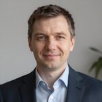 Портрет уверенного российского бизнесмена с дружелюбным взглядом на нейтральном размытом фоне студии