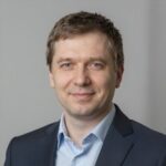 Портрет уверенного российского бизнесмена с дружелюбным взглядом на нейтральном размытом фоне студии